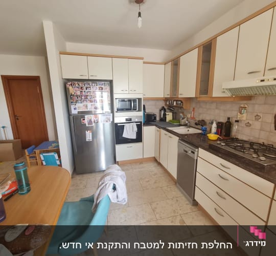 מטבח עם ארונות לבנים, תנור, כיריים ומקרר